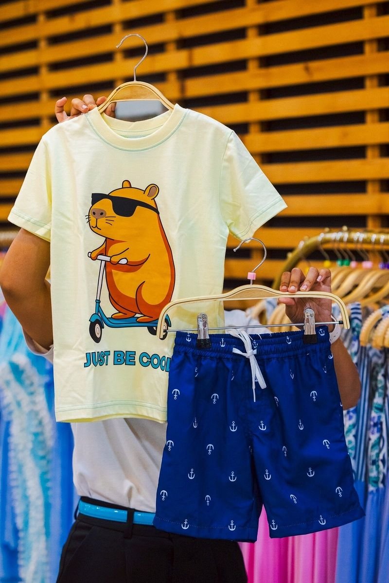 Yellow T-shirt with a cartoon print and navy swim shorts with anchors on hangers